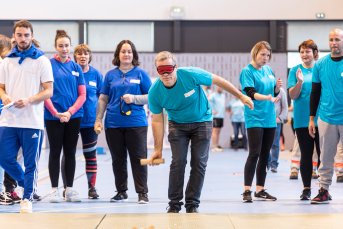 Un participant pratique la boccia avec un masque occultant sur les yeux