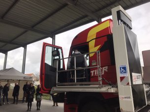 La plateforme élévatrice est déplié le long de la portière conducteur. Jérémy est en train de déplacer sur cette plateforme pour descendre du véhicule