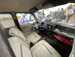 Photo de l'intérieur de la 4L pris par la vitre du côté passager. On y voit les deux sièges avant de couleur crème