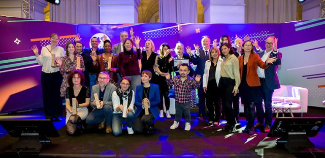 Photo prise lors de la remise de prix Activateurs de progrès 2023, le 27 mars 2023 lors de l'URRH à Bordeaux. L'ensemble des lauréats pose sur la scène, avec les trophées à la main. Sont également présents sur scène les animateurs de la soirée et des représentants de l'Agefiph dont le président et le directeur général.