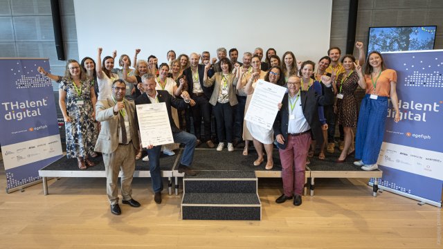 Les 22 signataires sont réunis sur scène avec les organisateurs et lèvent le poing