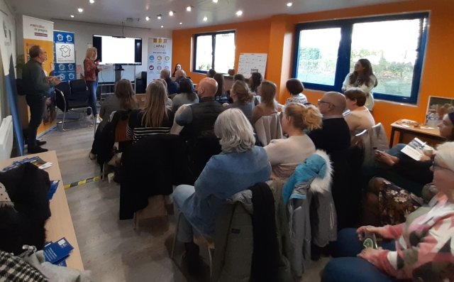 Une assemblée écoute une intervention d'une intervenant de Proch'emploi