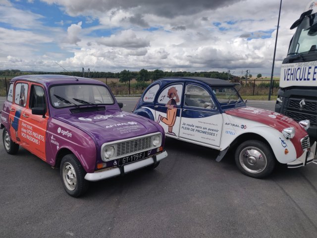 Photo de la 4L orange et violette sur la gauche et la 2CV violette bleue et blanche qui prendront la course avec les équipages Agefiph et Aftral