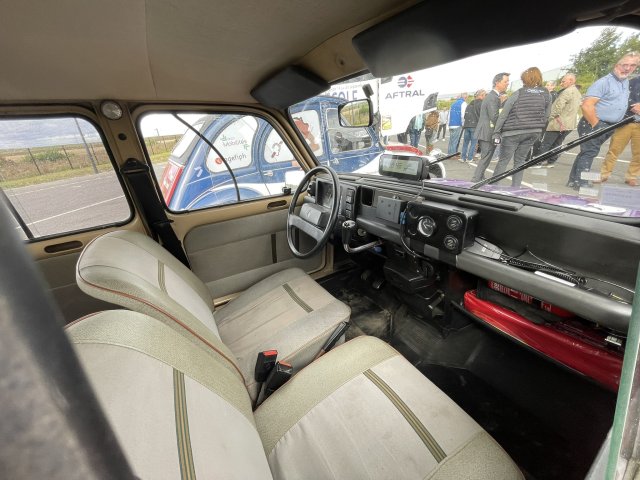 Photo de l'intérieur de la 4L pris par la vitre du côté passager. On y voit les deux sièges avant de couleur crème