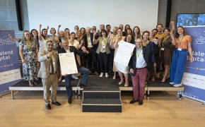 Les 22 signataires sont réunis sur scène avec les organisateurs et lèvent le poing