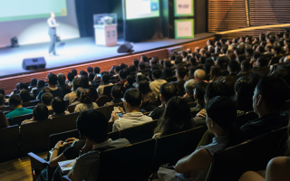 Plusieurs personnes assistent à une conférence dans un auditorium