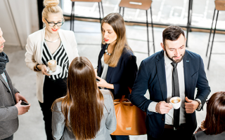 Plusieurs individus discutent ensemble lors d'un événement professionnel