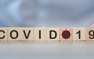 dé avec les lettres COVID-19