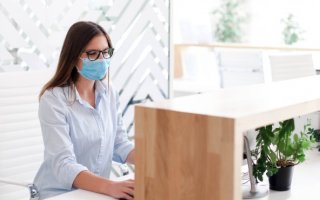 Une réceptionniste porte un masque