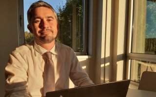 Nouveau délégué régional de Bretagne assis derrière son bureau devant son ordinateur