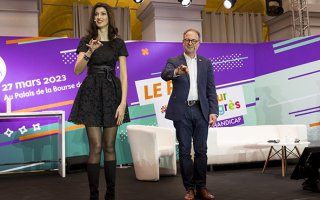 Sophie Vouzelaud et Hugues Defoy qui animent la cérémonie de remise de prix activateur de progrès, en train de pratiquer la langue des signes française. Sophie Vouzelaud explique quelques signes utiles.