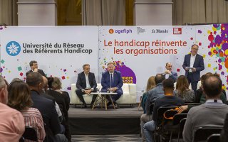 Photo de l'ouverture de l'URRH, on voit le public de dos et les intervenants sur scène.