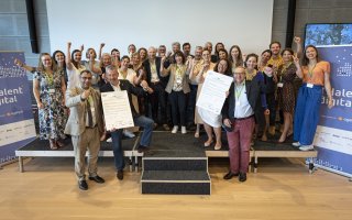 Les 22 signataires sont réunis sur scène avec les organisateurs et lèvent le poing