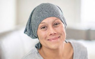 Couverture de la publication de l'Agefiph Concilier cancer et travail, Photo d'une femme de face avec foulard sur tete