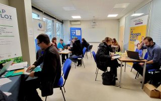 Des personnes sont présentes sur des stands pour prendre des renseignements