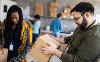 photo, 2 personnes manipulent des cartons pour expédition