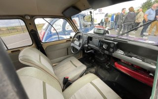 Photo de l'intérieur de la 4L pris par la vitre du côté passager. On y voit les deux sièges avant de couleur crème